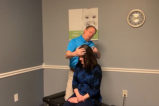 Auto Injury Chiropractor Checking Back of the Head of Patient in Fort Mill South Carolina