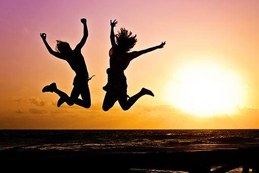 Silhoutte of Two Fort Mill SC Ladies Jumping Happily After Availing Chiropractor Services