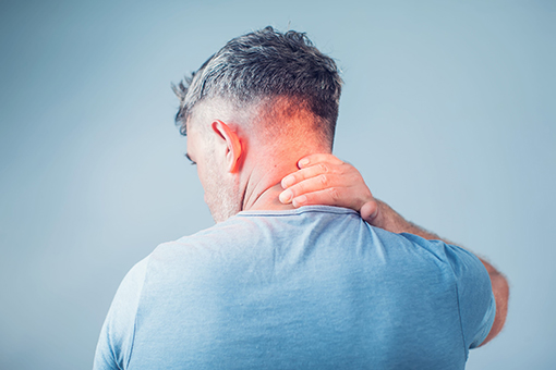 Fort Mill Man In Need of Hako-Med Therapy Holding Back of Neck in Pain